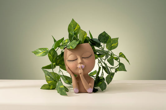 Decorative figurine with plant on a gradient wall