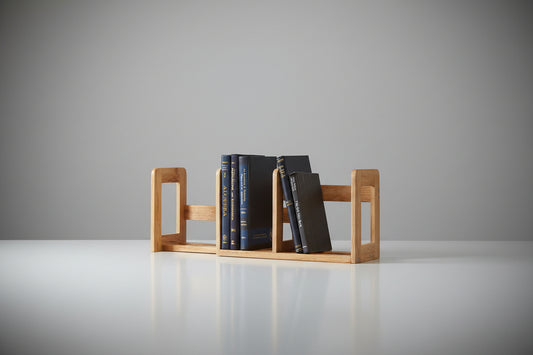 Wooden bookends holding books on a shelf against a white wall.