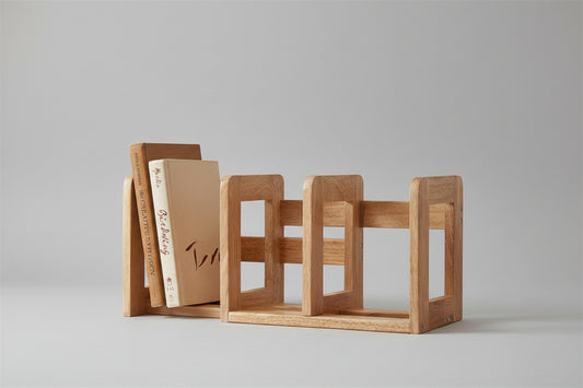 Wooden bookend holding books on a shelf against a white wall.