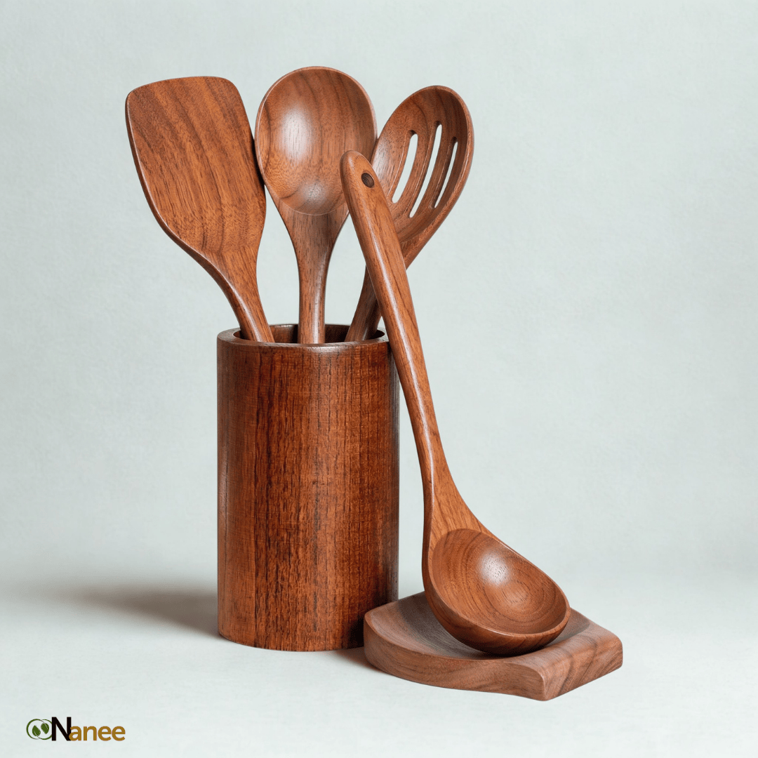 Set of wooden kitchen utensils including a ladle, spatula, and spoon in a cylindrical holder on a light gray background.