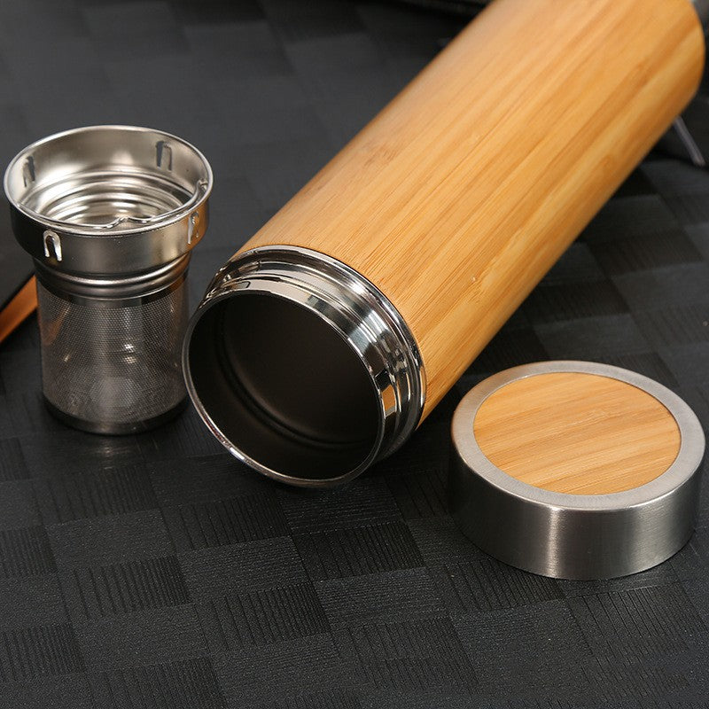 Sustainable Wooden and metal travel mug on a black textured surface