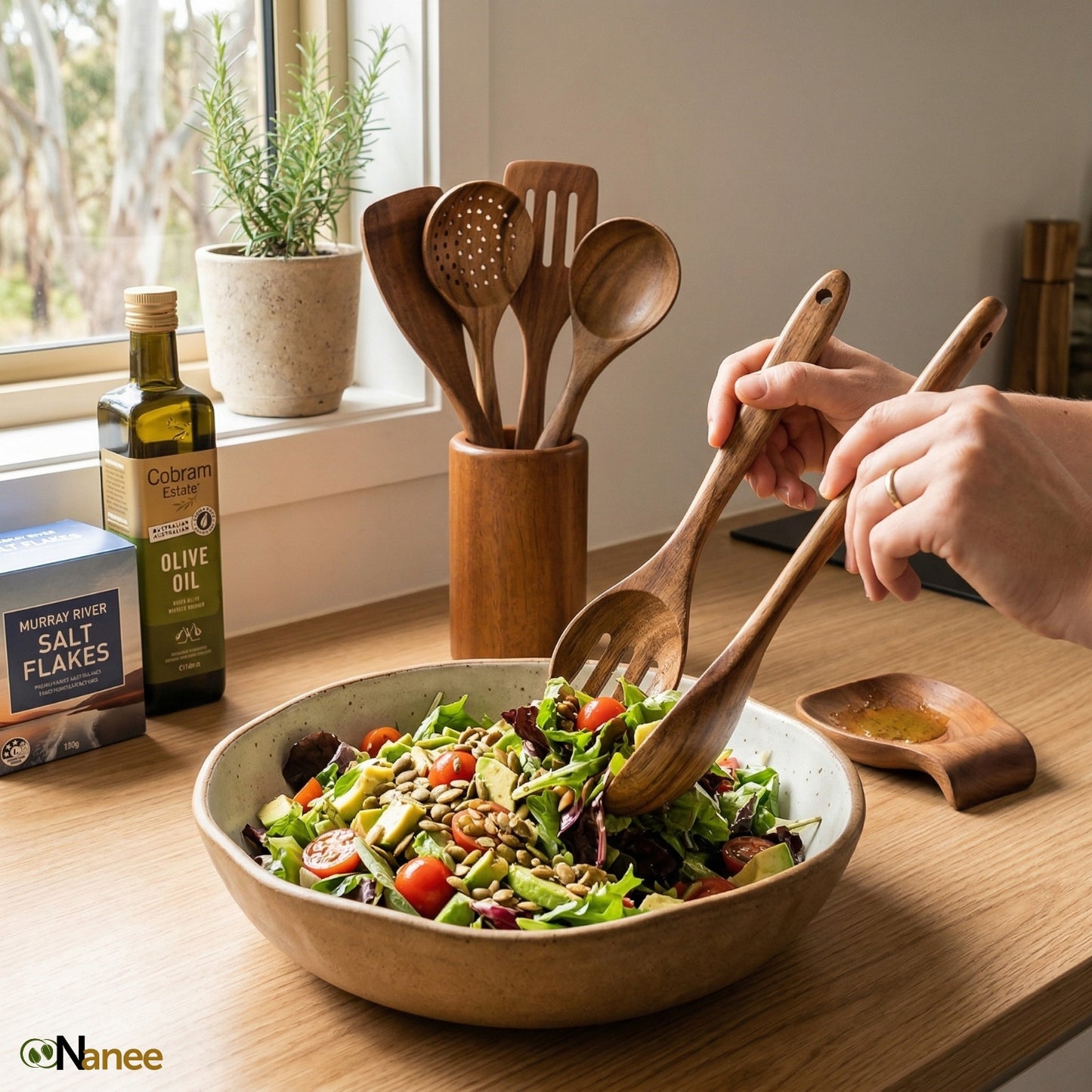 Person using teak wooden spatula to mix a salad in a kitchen setting