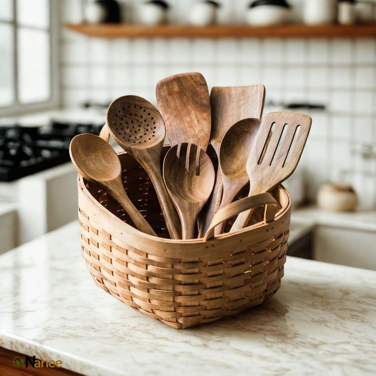 Premium Teak Wood utensils in a woven basket on a marble countertop with a blurred kitchen background.
